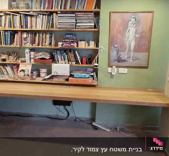 שולחן עץ עם מדפים מלאים בספרים וכלי כתיבה